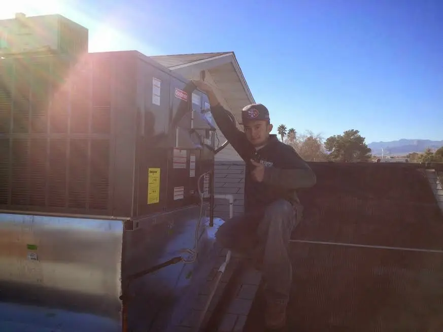 HVAC technician performing AC Tune-Up on a rooftop unit in Ashtabula